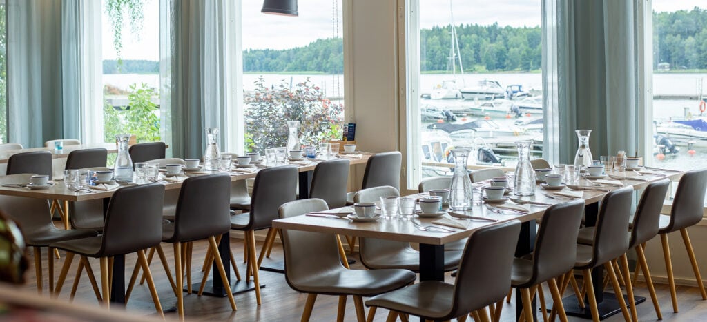Katetut pitkät pöydät ja merinäköala satamaan