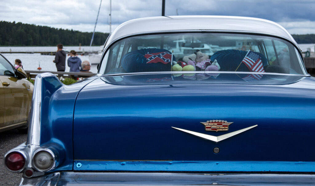 Hieno vanha sininen "amerikanrauta" auto, sini-valkoisella värityksellä aprkeerattuna satamassameren äärellä